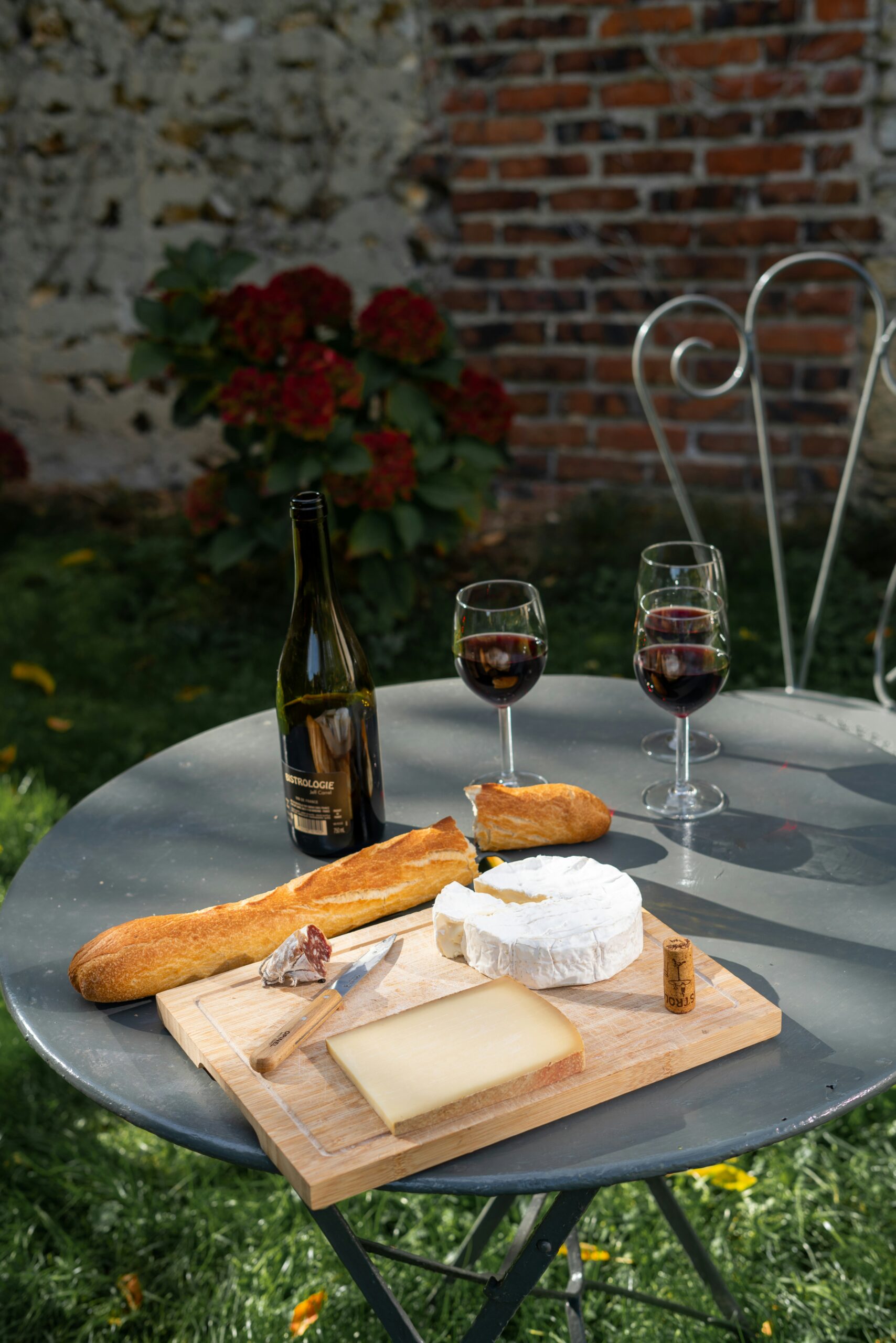 Mesa con quesos, vinos y baguettes francesas
